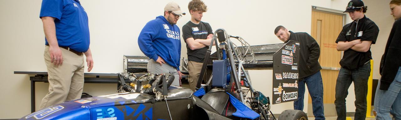 A race car with men in it and standing around it